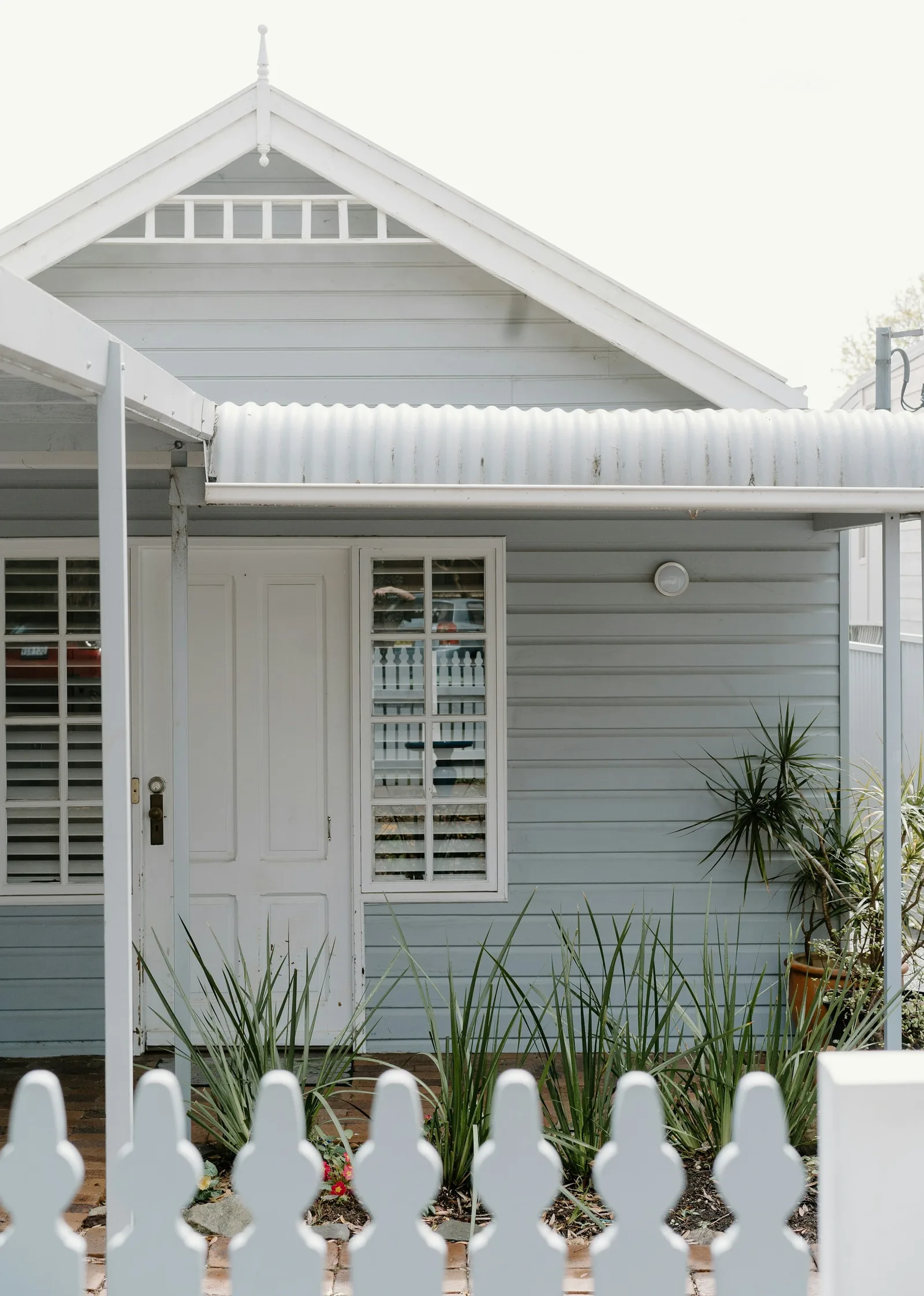 Home clad in painted weatherboards with white shutters