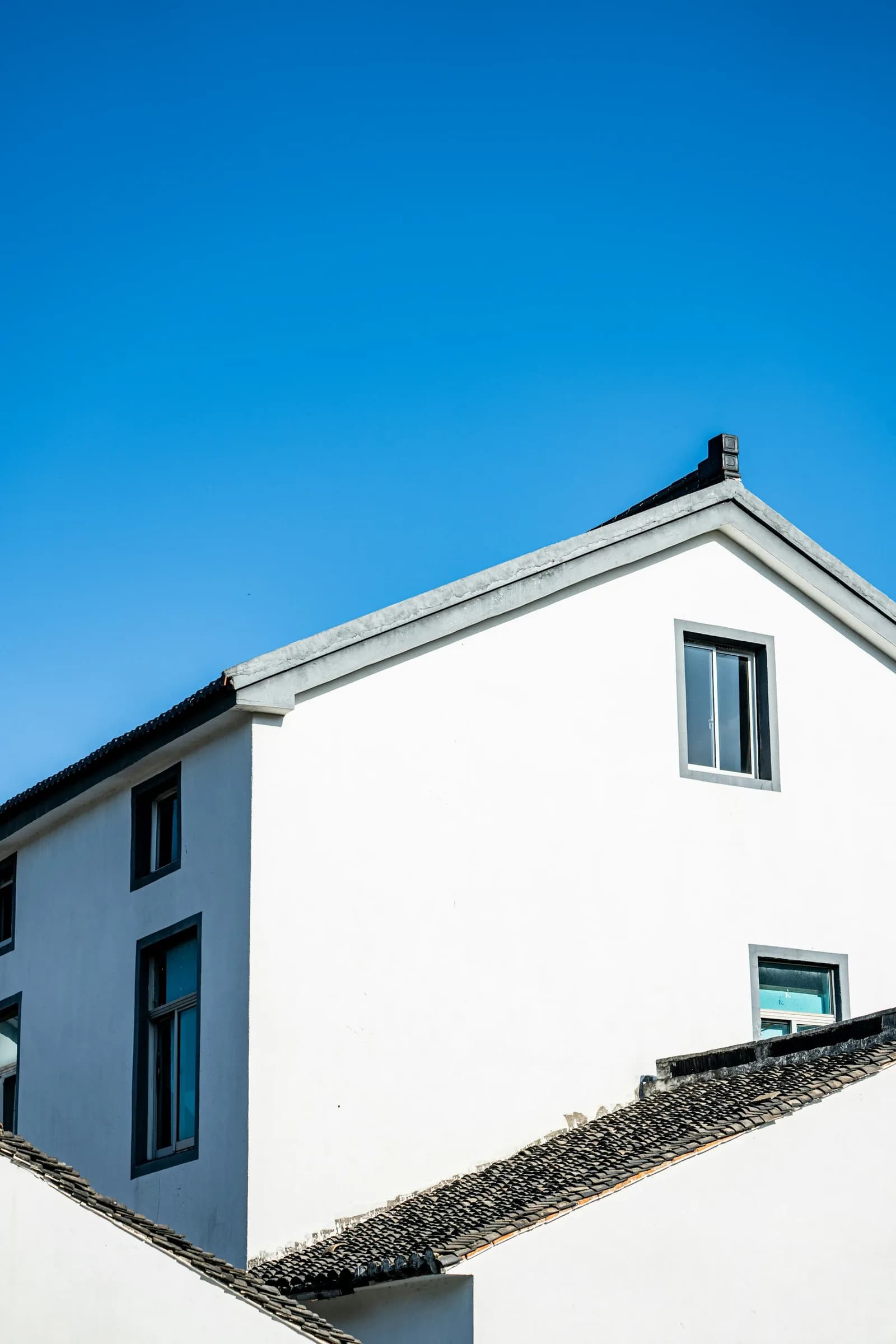 White gable wall and eaves against a blue sky